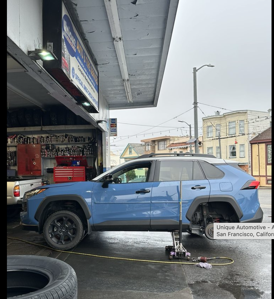 Blue Toyota RAV4 at Unique Automotive during suspension or wheel service