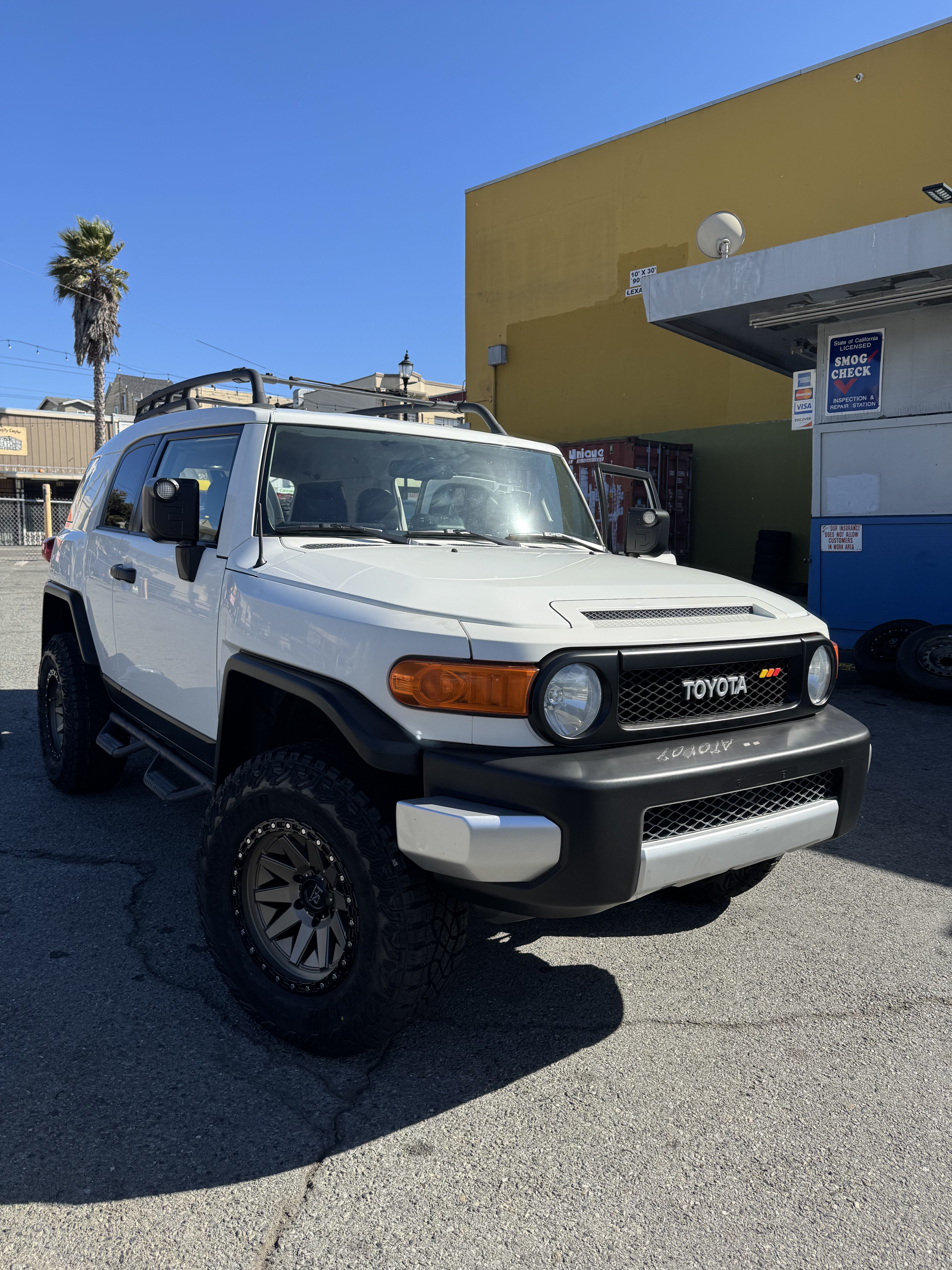 Lifted white Toyota FJ Cruiser outside Unique Automotive